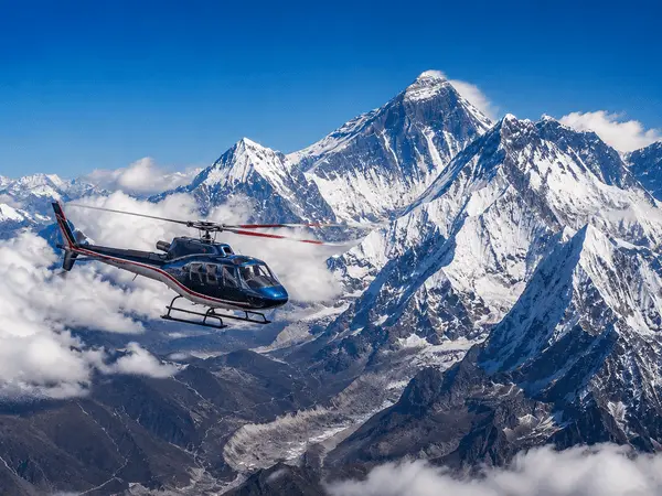 Helicopter over snow-covered mountain peaks
